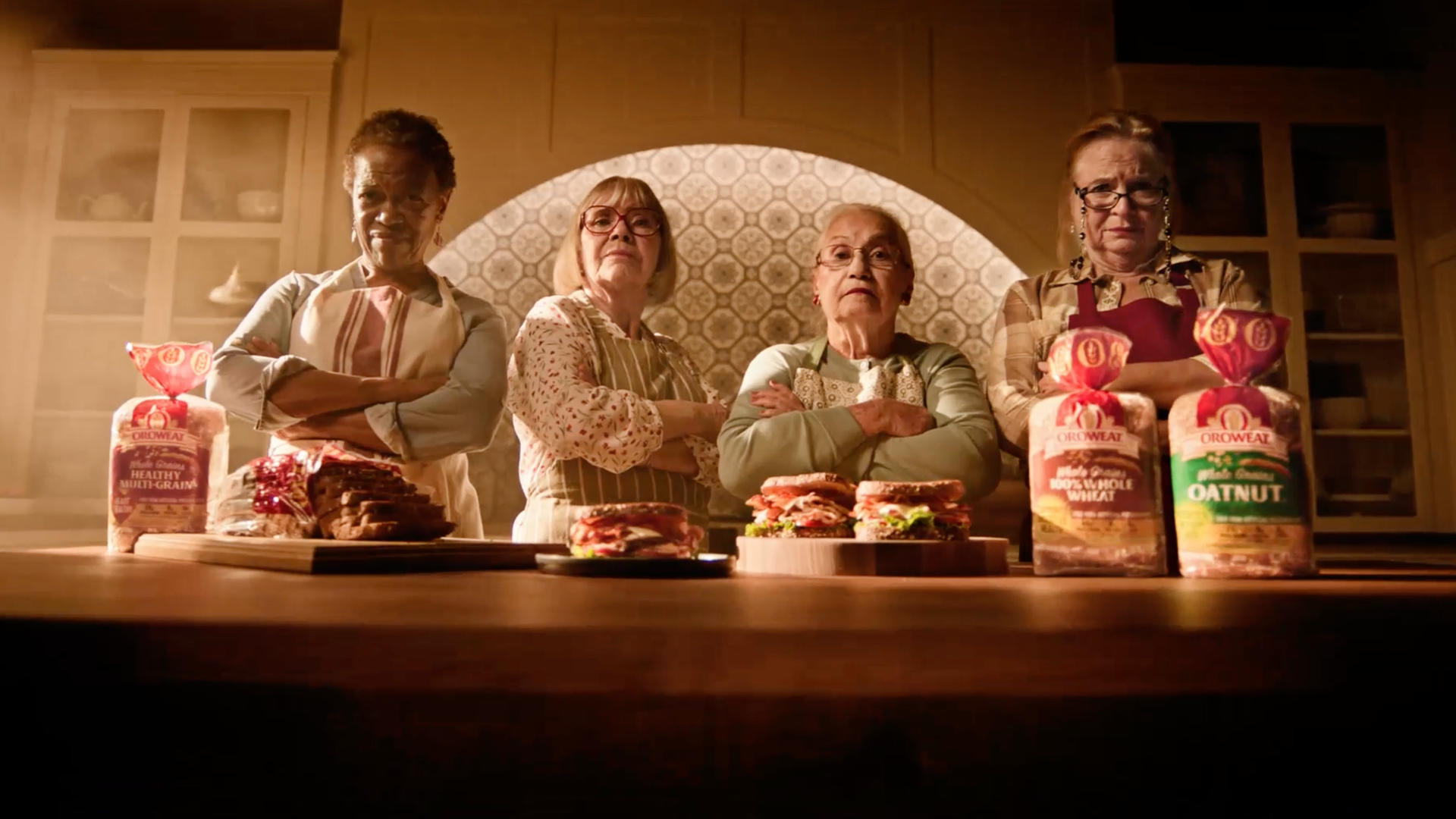 Four women in kitchen with Oroweat bread and sandwiches